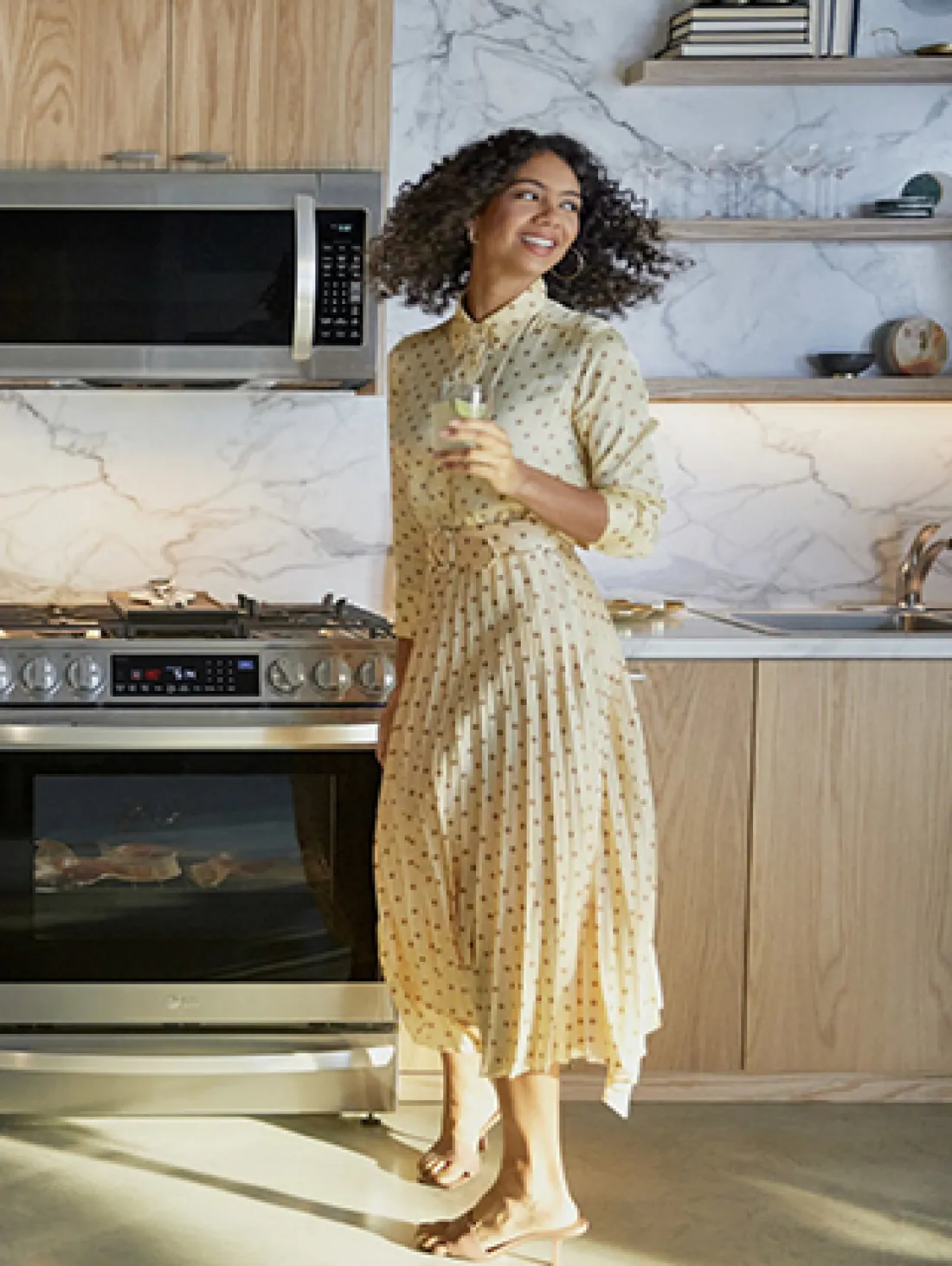 Woman smiling in a modern kitchen — home appliances key visual